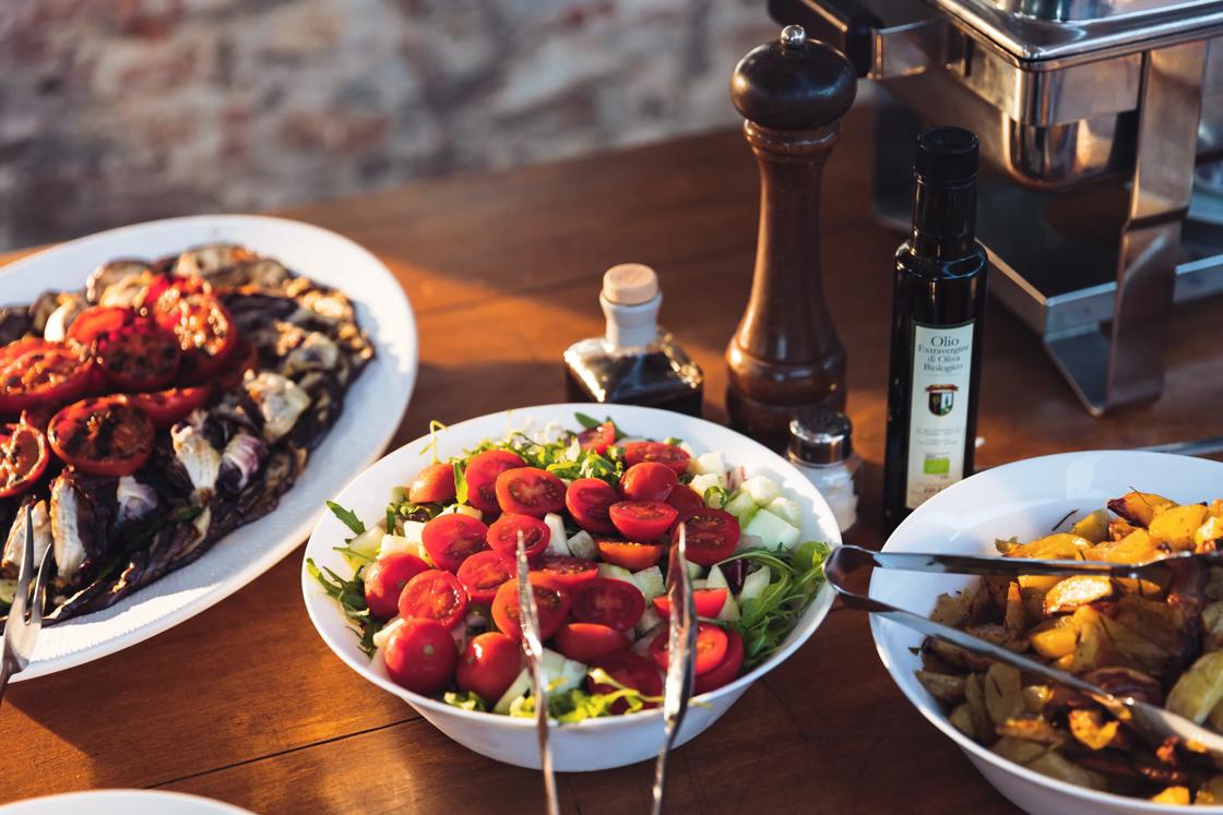 A fresh salad of arugula, cucumbers and cherry tomatoes on a buffet table in Tuscany.