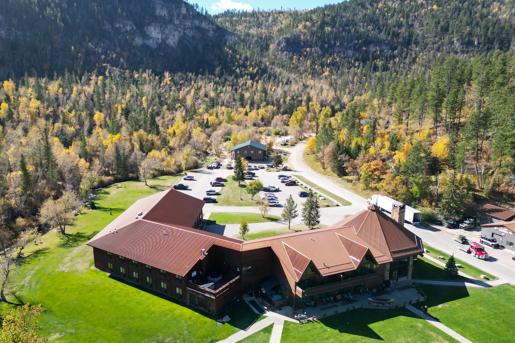 Arial view of the  Spearfish Canyon lodge in Lead. A green pavilion and a mountainous horizon can be seen.