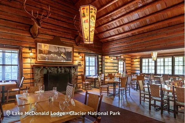 Russell's Fireside Dining Room with rustic log-cabin architecture inside the historic Lake McDonald Lodge at Glacier National Park in Montana. Text overlay reads: Lake McDonald Lodge, Glacier National Park.