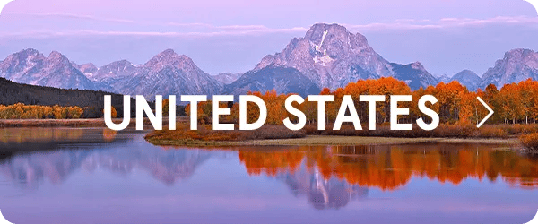 Scenic landscape featuring a calm river reflecting vibrant autumn orange trees and rugged, majestic mountains under a soft purple sky, with the text "UNITED STATES" overlayed in bold white letters in the center.
