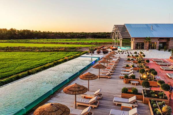 The infinity pool and deck overlooking the rice fields at the Quinta da Comporta - Wellness Boutique Resort in Carvalhal, Portugal.