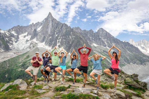 A group of people enjoying a Backroads guided adventure tour in the French Alps, posing with the Mont Blanc in the background. 