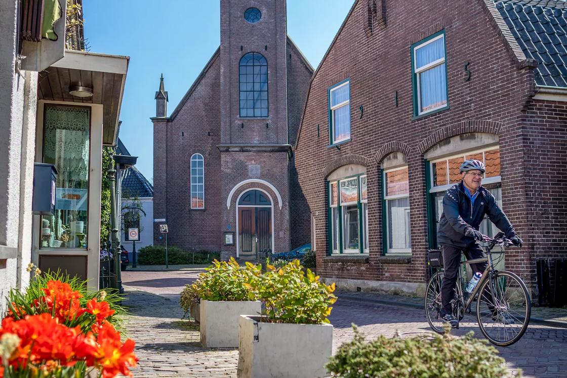 A Backroads cyclist rides through the narrow streets of a town in the Netherlands.