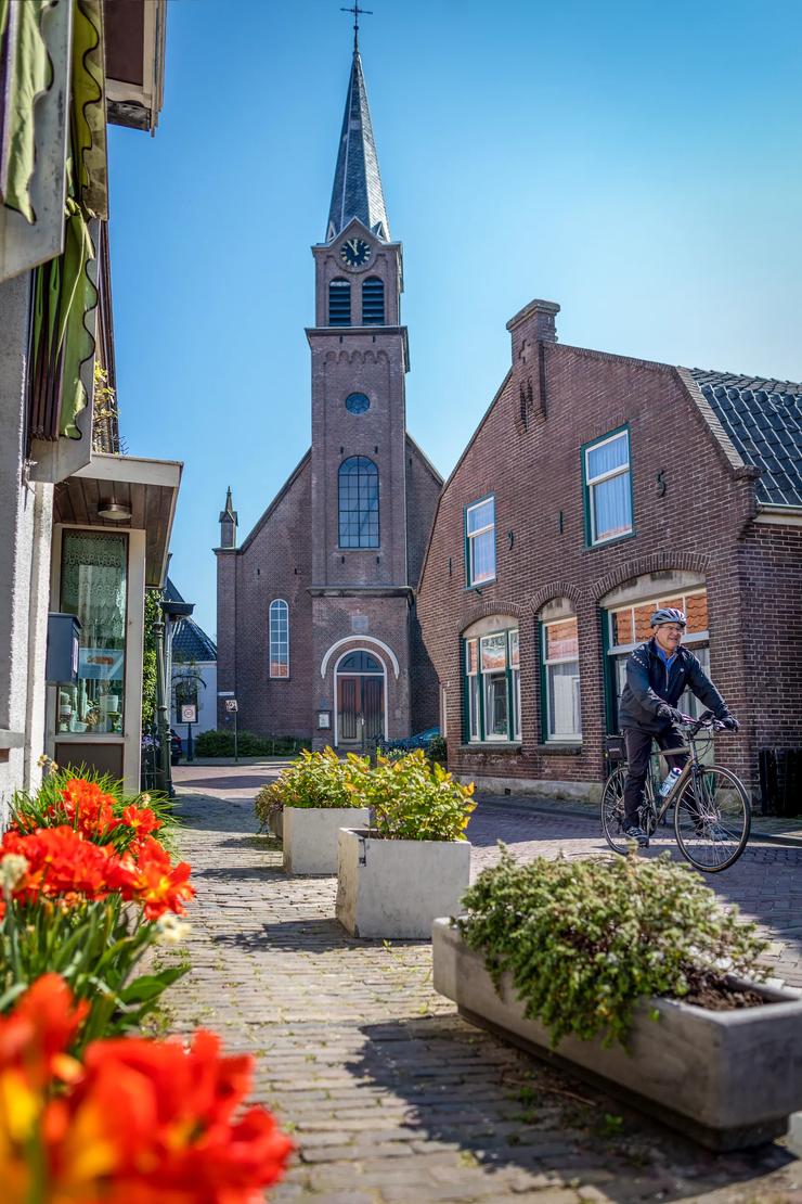A Backroads cyclist rides through the narrow streets of a town in the Netherlands.