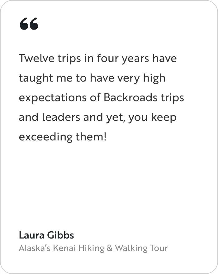 A testimonial card featuring a quote from a traveler named Laura Gibbs from Alaska's Kenai Hiking & Walking Tour. The main body text reads: "Twelve trips in four years have taught me to have very high expectations of Backroads trips and leaders and yet, you keep exceeding them!" 