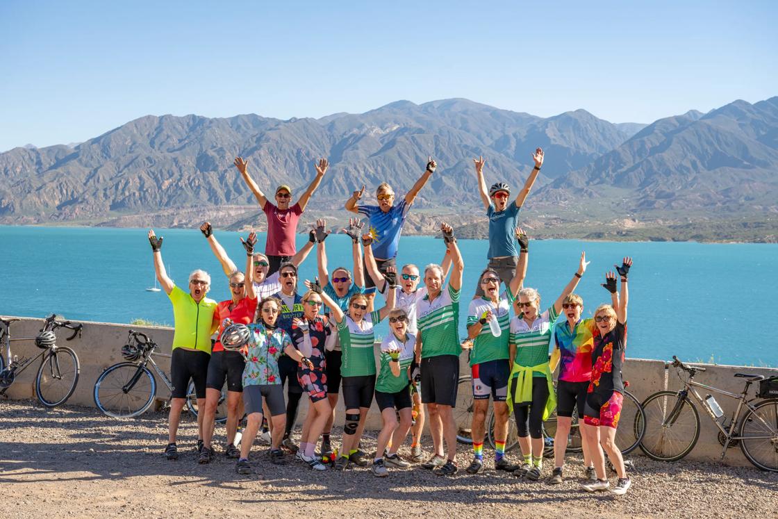 Bike riders celebrate next to a lake on the Backroads Argentina's Mendoza Wine Country & Andes Multi-Adventure Tour.