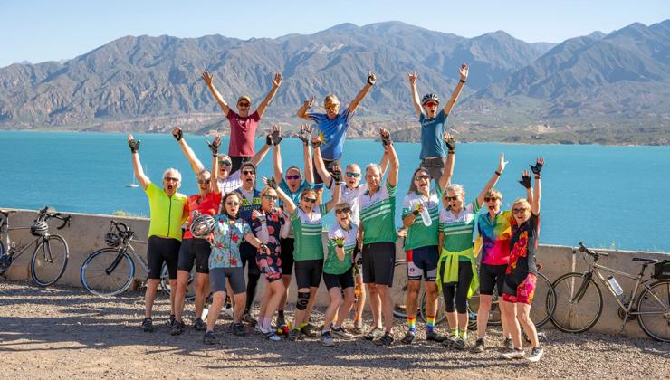 Bike riders celebrate next to a lake on the Backroads Argentina's Mendoza Wine Country & Andes Multi-Adventure Tour.