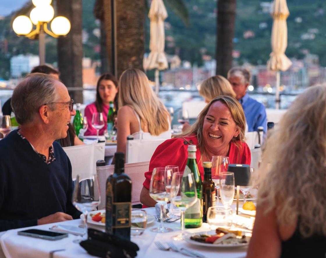 Guests laughing over dinner in the Cinque Terre.
