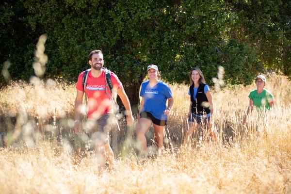 A group of people hiking along a trail through a field of tall, dry, golden-brown grass. during an active adventure trip with Backroads.