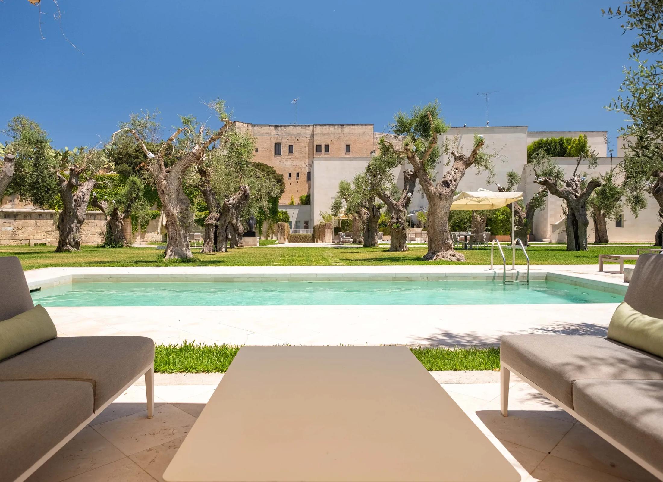 La Fiermontina Luxury Home in Lecce, Puglia, Italy, featuring a minimalist pool and lounge area set among ancient olive trees.