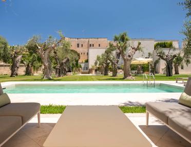 La Fiermontina Luxury Home in Lecce, Puglia, Italy, featuring a minimalist pool and lounge area set among ancient olive trees.