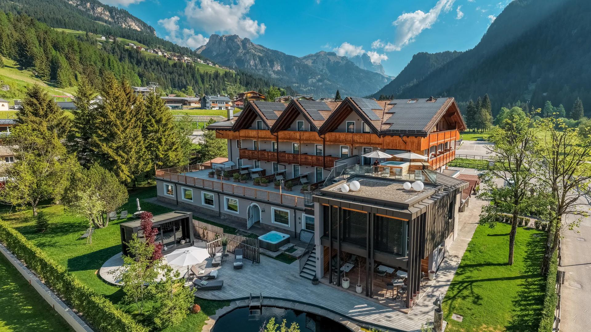 An exterior view of the Alp Hotel, set against a scenic mountainous backdrop.