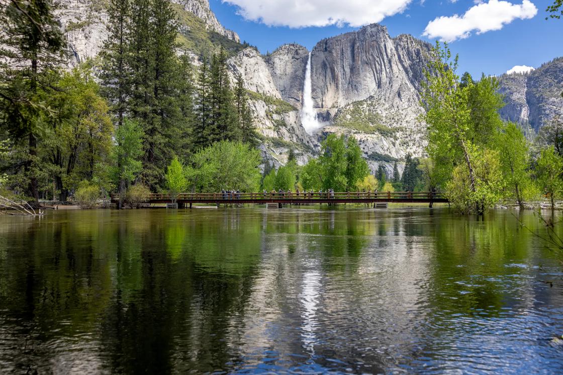 A view of a waterfall in Yosemite Valley from across a lake.