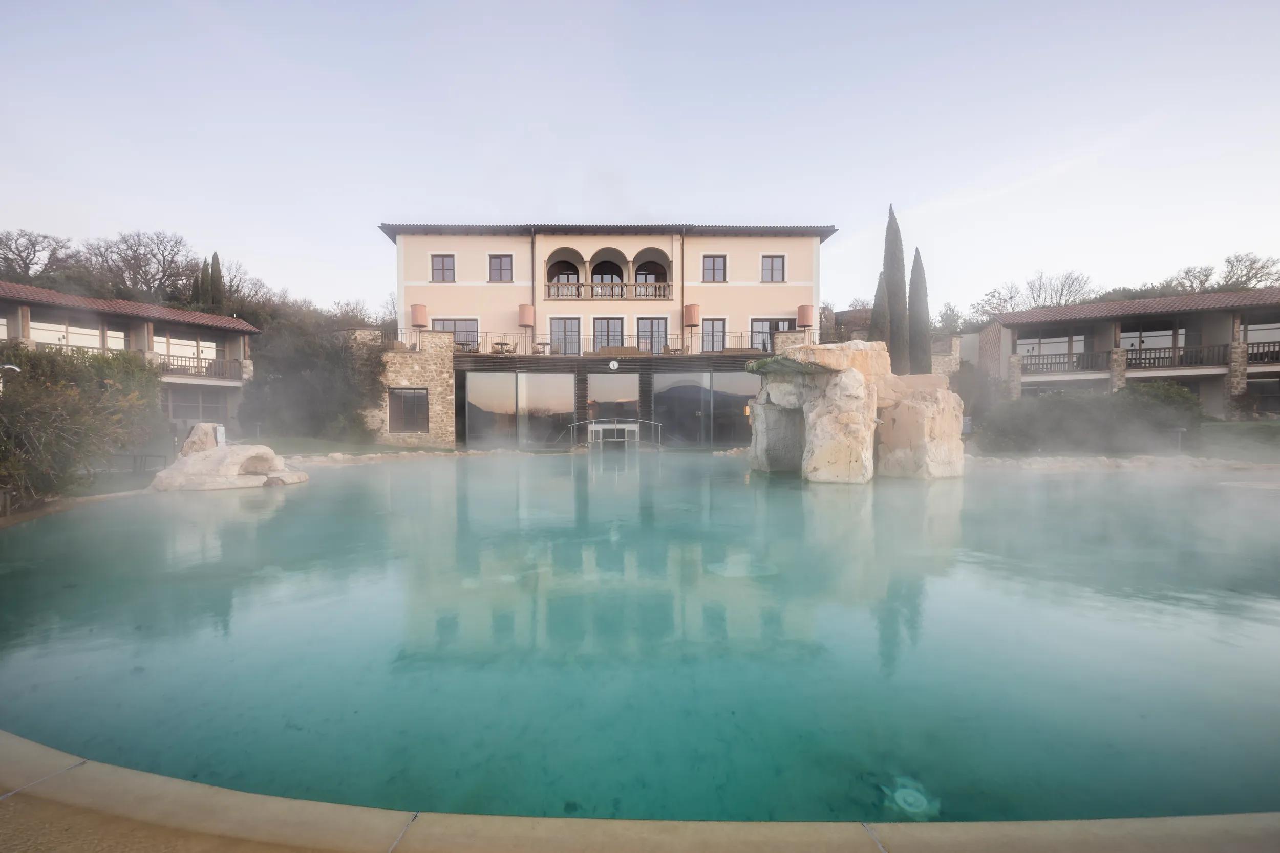 The steaming thermal pool and exterior of Adler Spa Resort Thermae in Bagno Vignoni (San Quirico d'Orcia), Tuscany, Italy.