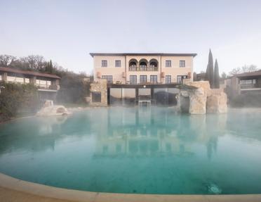 The steaming thermal pool and exterior of Adler Spa Resort Thermae in Bagno Vignoni (San Quirico d'Orcia), Tuscany, Italy.