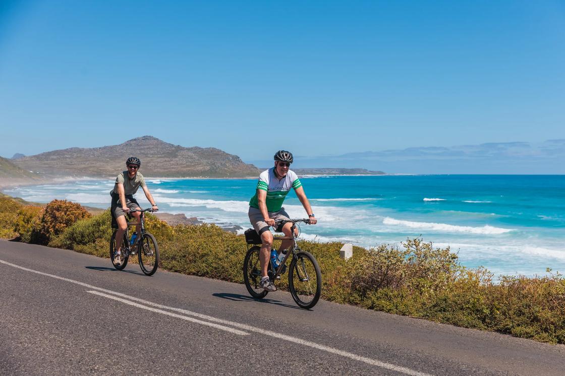 Two Backroads cyclists riding next to the ocean on the South Africa & Botswana Active Safari trip