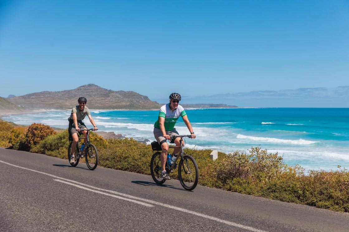 Two Backroads cyclists riding next to the ocean on the South Africa & Botswana Active Safari trip