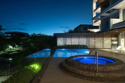The outdoor pool and spa area seen at nighttime at the Hotel Indigo Galapagos.