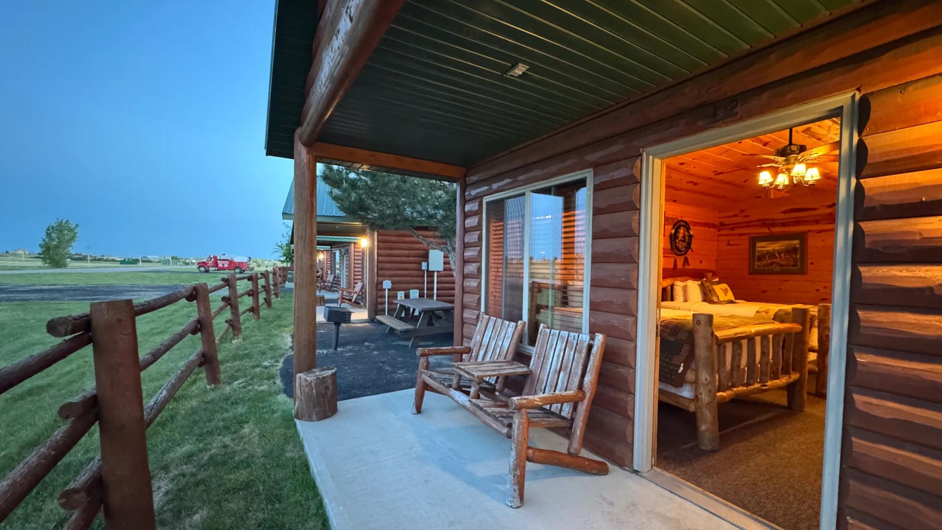 A porch view of the rustic log-style  cabins at Badlands Frontier Cabins located at, Wall, South Dakota, near Badlands National Park.