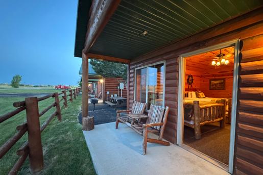 A porch view of the rustic log-style  cabins at Badlands Frontier Cabins located at, Wall, South Dakota, near Badlands National Park.