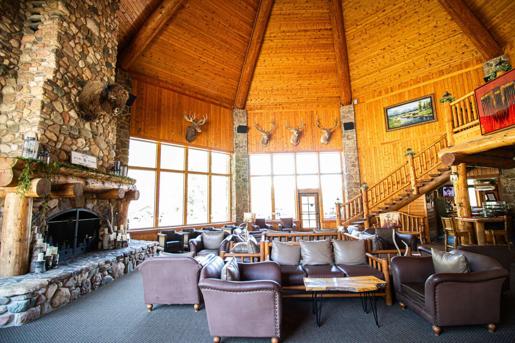 Rustic lobby featuring mounted animal heads, a large fireplace, and lounge area of the Spearfish Canyon lodge in Lead.