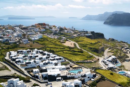 Aerial view of the Santo Pure Oia Suites and Villas in Santorini, characterized by its whitewashed architecture and multiple swimming pools.
