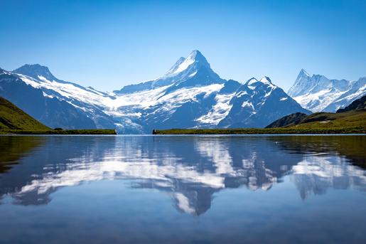 Iconic view of the Schreckhorn mountain reflected in the calm waters of Bachalpsee, located above Grindelwald in the Bernese Oberland of the Swiss Alps.
