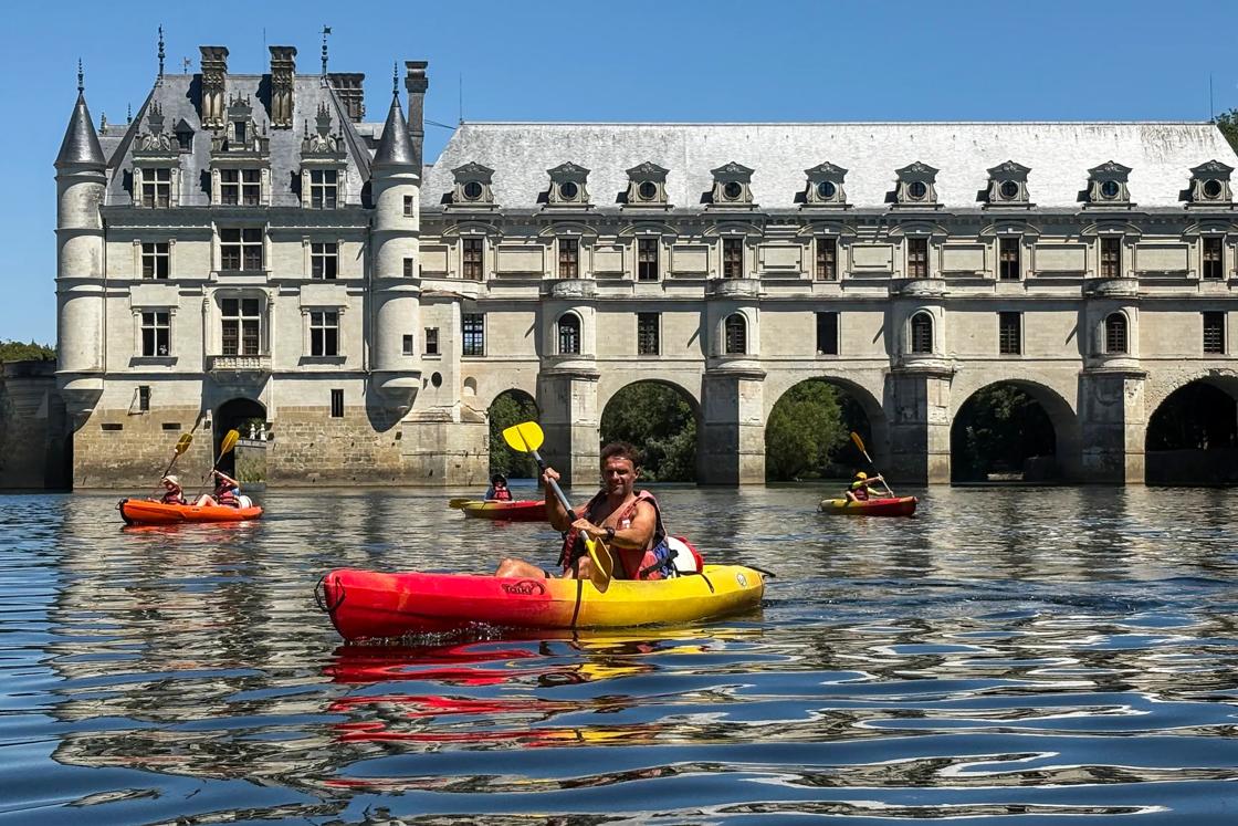 Backroads guests kayaking the Cher river in front of  Le Château de Chenonceau