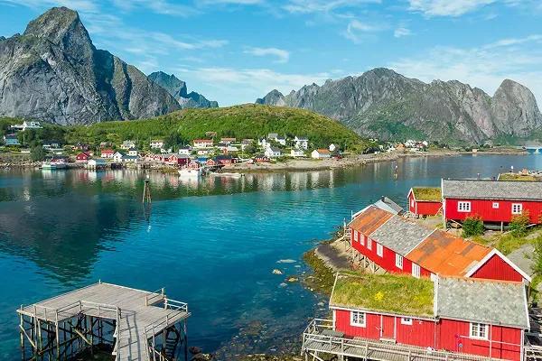 The scenic fishing village of Reine with red traditional fishing huts, in the Lofoten Islands of Norway.